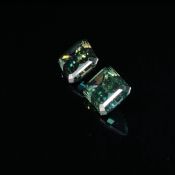 TWO SIMILAR LOOSE GREEN MOISSANITE GEMSTONES. RECTANGULAR CUT WITH CUT CORNERS. THE FIRST GREEN