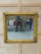 AN ANTIQUE CARVED GILT WOOD FRAME WITH LATER BEVEL MIRROR PLATE. 86 x 90cms.