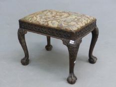 A GEORGE III MAHOGANY STOOL, THE FLORAL WOOLWORK DROP IN SEAT ABOVE AN APRON BAND OF OVALS CENTRED