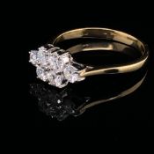 AN 18ct YELLOW GOLD DIAMOND SIX STONE CLUSTER RING, EACH DIAMOND ROUND BRILLIANT CUT IN A FOUR