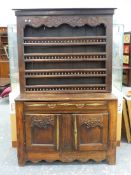 AN EARLY 19th C. FRENCH PROVINCIAL OAK DRESSER, ROSETTES FLANKING FOLIAGE CARVED IN RELIEF ON THE