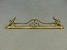 A BRASS FIRE KERB WITH FIRE IRON SUPPORTS AT EACH END, THE BASE RAIL OF THREE RECESSED STEPS. W