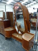 AN ART DECO WALNUT DRESSING TABLE, THE GLASS TOPPED QUARTER ROUND CUPBOARDS FLANKING TWO DRAWERS