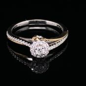 A 9ct WHITE AND YELLOW GOLD DIAMOND RING, WITH DIAMOND SET SHOULDERS AND A DIAMOND SET STAR. TOTAL