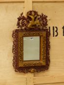 A RECTANGULAR MIRROR WITHIN A BURMESE RED LACQUERED FRAME CRESTED BY A GILT MAN DANCING AMONGST