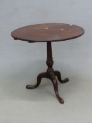 A GEORGE III MAHOGANY TRIPOD TABLE, THE CIRCULAR TOP ON A GUN BARREL COLUMN ENDING IN A SPIRALLY