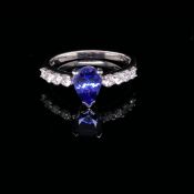 A PLATINUM, TANZANITE AND DIAMOND RING. THE PEAR SHAPE TANZANITE IN A TWO CLAW AND CORNER SETTING,