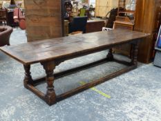 AN OAK REFECTORY TABLE, THE CLEATED FOUR PLANK TOP ON BALUSTER TURNED LEGS JOINED AT THE SQUARE