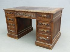 A VICTORIAN OAK PEDESTAL DESK, A GADROONED EDGE ENCLOSING THE LEATHER INSET TOP, THE THREE APRON