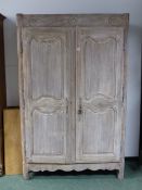 A 19th C. FRENCH LIMED OAK ARMOIRE, THREE ROSETTE ROUNDELS CARVED ABOVE TWIN PANELLED DOORS AND A
