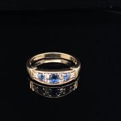 A 9CT YELLOW GOLD, SAPPHIRE AND DIAMOND BOAT SHAPE 1/2 HOOP RING SET WITH THREE GRADUATED BLUE