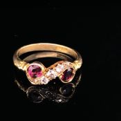 AN ANTIQUE 18ct YELLOW GOLD RUBY AND DIAMOND SCROLL RING, SET WITH TWO RUBIES AND FIVE GRADUATED