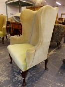 A GEORGE III WING BACKED ARMCHAIR, THE MAHOGANY LEGS ON PAD FEET