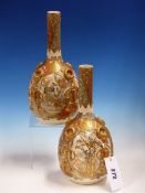 A PAIR OF SATSUMA BOTTLE VASES, THE FIGURE AND GARDEN RESERVES SEPARATED BY GILT TASSELS TIED TO