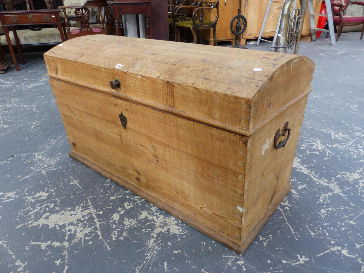 A PINE ROUND ARCH LIDDED TRUNK, THE RECTANGULAR SIDES TAPERING TO A PLINTH FOOT. W 116cms