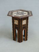 AN ISLAMIC HEXAGONAL TABLE, THE TOP WITH AN INSCRIBED MOTHER OF PEARL ROUNDEL WITHIN AN EBONY