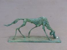 A GREEN PATINATED BRONZE STYLISED DOG WALKING AND SCENTING THE RECTANGULAR BASE. W 65cms.