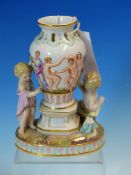 A MEISSEN VASE GROUP WITH TWO PUTTI ON THE OVAL BASE, THE VASE WITH DANCING NAKED LADIES AND PUTTI
