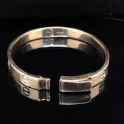 A 9ct YELLOW GOLD SOLID HINGED BABY / CHILD'S LOVE BANGLE. WEIGHT 14.3grms.