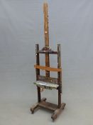 A VINTAGE STUDIO ARTISTS EASEL ADJUSTABLE ON A TURNED WOOD SCREW COLUMN, THE CENTRAL SUPPORT. H