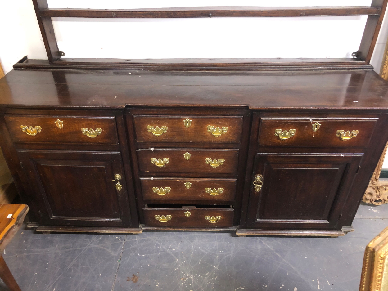 AN 18TH CENTURY COUNTRY OAK DRESSER BASE WITH CENTRAL DRAWERS AND PANEL SIDES.