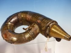AN AFRICAN IRON POWDER HORN, THE RAMS HORN SHAPE MOUNTED WITH BRASS STRAPWORK AND WITH WHITE METAL