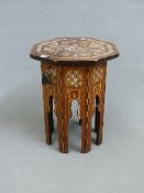 AN ISLAMIC TABLE, THE HEXAGONAL TOP CONVERTED INTO A LOCKABLE LID OVER A QUILTED INTERIOR, THE TOP