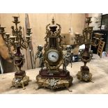 AN ITALIAN IMPERIAL GILT BRASS AND RED CERAMIC CLOCK GARNITURE, THE ENAMEL DIAL IN A LYRE SHAPED