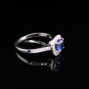 A PLATINUM SAPPHIRE AND DIAMOND RING. THE PRINCIPLE SAPPHIRE A CUSHION CUT IN A CLASSIC DIAMOND HALO