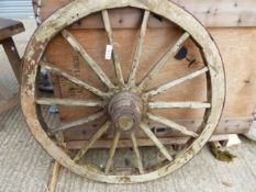 A WOODEN WAGON WHEEL.