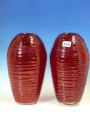 A PAIR OF RUBY GLASS OVOID VASES HORIZONTALLY TRAILED IN POWELL STYLE. H 28cms.