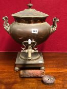 AN EARLY VICTORIAN TWO HANDLED COPPER EPERGNE, THE INTERIOR HEATED BY AN IRON WEIGHT DROPPING INTO A