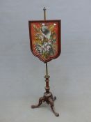 A VICTORIAN MAHOGANY POLE SCREEN, THE BERLIN FLORAL NEEDLEWORK BANNER WITHIN SHIELD SHAPED FRAME