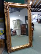 AN IMPRESSIVE LARGE GILT FRAMED BEVEL EDGE WALL MIRROR. 127 x 216cms.