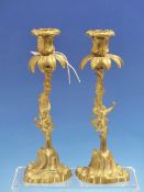 A PAIR OF BRASS CANDLESTICKS, THE PALMATE DRIP PANS PIERCED TO TAKE GLASS DROPS ABOVE FOLIATE