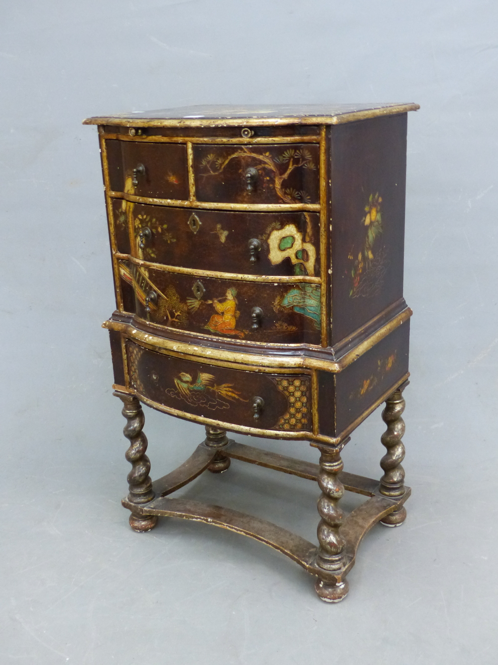A CHINOISERIE SIMULATED LACQUER SIDE CABINET WITH A BRUSHING SLIDE ABOVE A CONFIGURATION OF FIVE