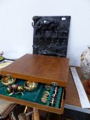 A CANTEEN OF BRONZE AND TEAK HANDLED CUTLERY TOGETHER WITH A CARVED HARDWOOD PANEL.