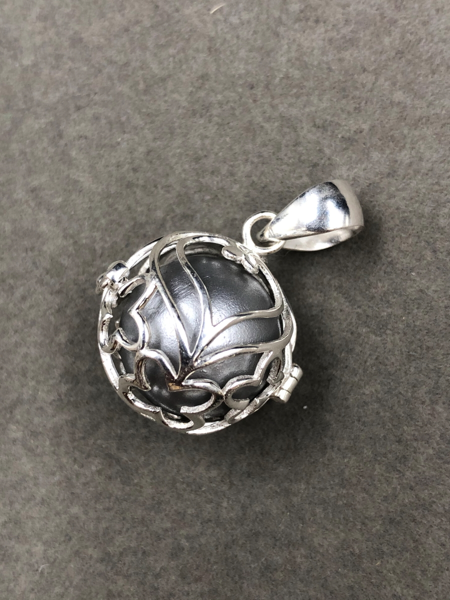 A SILVER CAGED MUSICAL BOLA ANGEL HARMONY CHIME BALL,THE CAGE DECORATED WITH HEARTS AND BUTTERFLIES.