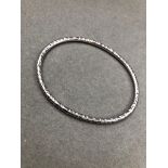 A SOLID SILVER HAMMERED FINISHED OVAL BANGLE, DATED 1988. WEIGHT 16.2grms.