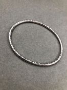 A SOLID SILVER HAMMERED FINISHED OVAL BANGLE, DATED 1988. WEIGHT 16.2grms.