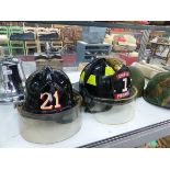 TWO AMERICAN FIRE SERVICE HELMETS, TWO MILITARY HELMETS, AND A LARGE FIRE BELL.