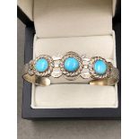 AN AMERICAN NAVAJO INDIAN SILVER CUFF BRACELET SET WITH THREE CABOCHON TURQUOISE STONES WITH