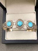 AN AMERICAN NAVAJO INDIAN SILVER CUFF BRACELET SET WITH THREE CABOCHON TURQUOISE STONES WITH