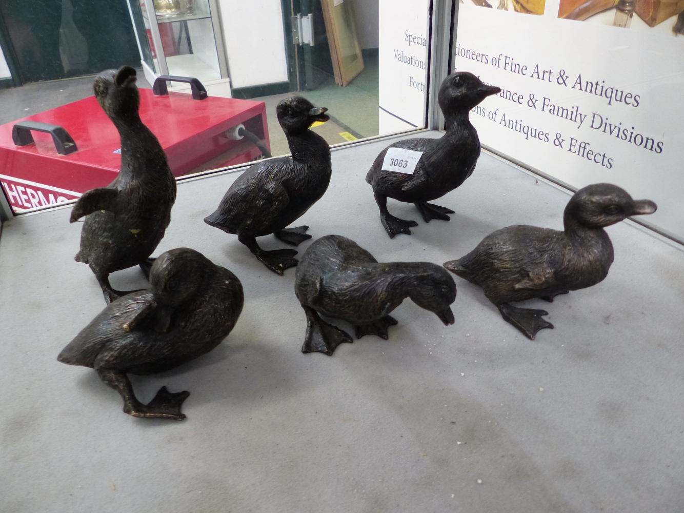 A BRONZE GROUP OF SIX INDIVIDUAL DUCKLINGS.