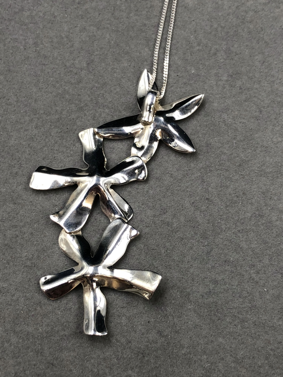 A SILVER FLORAL CONTEMPORARY STYLISED PENDANT SUSPENDED ON A SILVER CURB CHAIN. PENDANT LENGTH 7. - Image 4 of 5