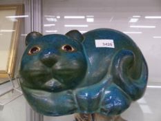 A GLAZED POTTERY CAT FIGURE.