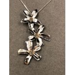 A SILVER FLORAL CONTEMPORARY STYLISED PENDANT SUSPENDED ON A SILVER CURB CHAIN. PENDANT LENGTH 7.