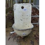 A WALL MOUNTED PAINTED ENAMEL WASH BASIN.