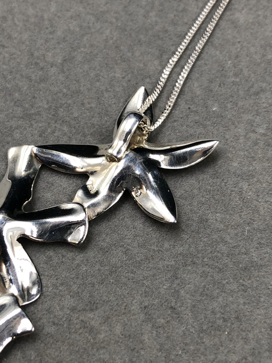 A SILVER FLORAL CONTEMPORARY STYLISED PENDANT SUSPENDED ON A SILVER CURB CHAIN. PENDANT LENGTH 7. - Image 5 of 5