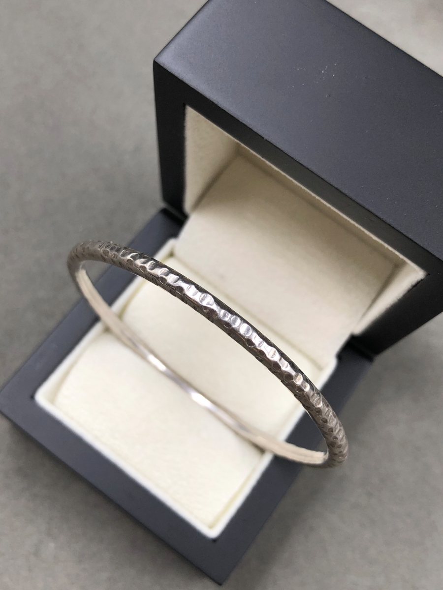 A SOLID SILVER HAMMERED FINISHED OVAL BANGLE, DATED 1988. WEIGHT 16.2grms. - Image 2 of 4